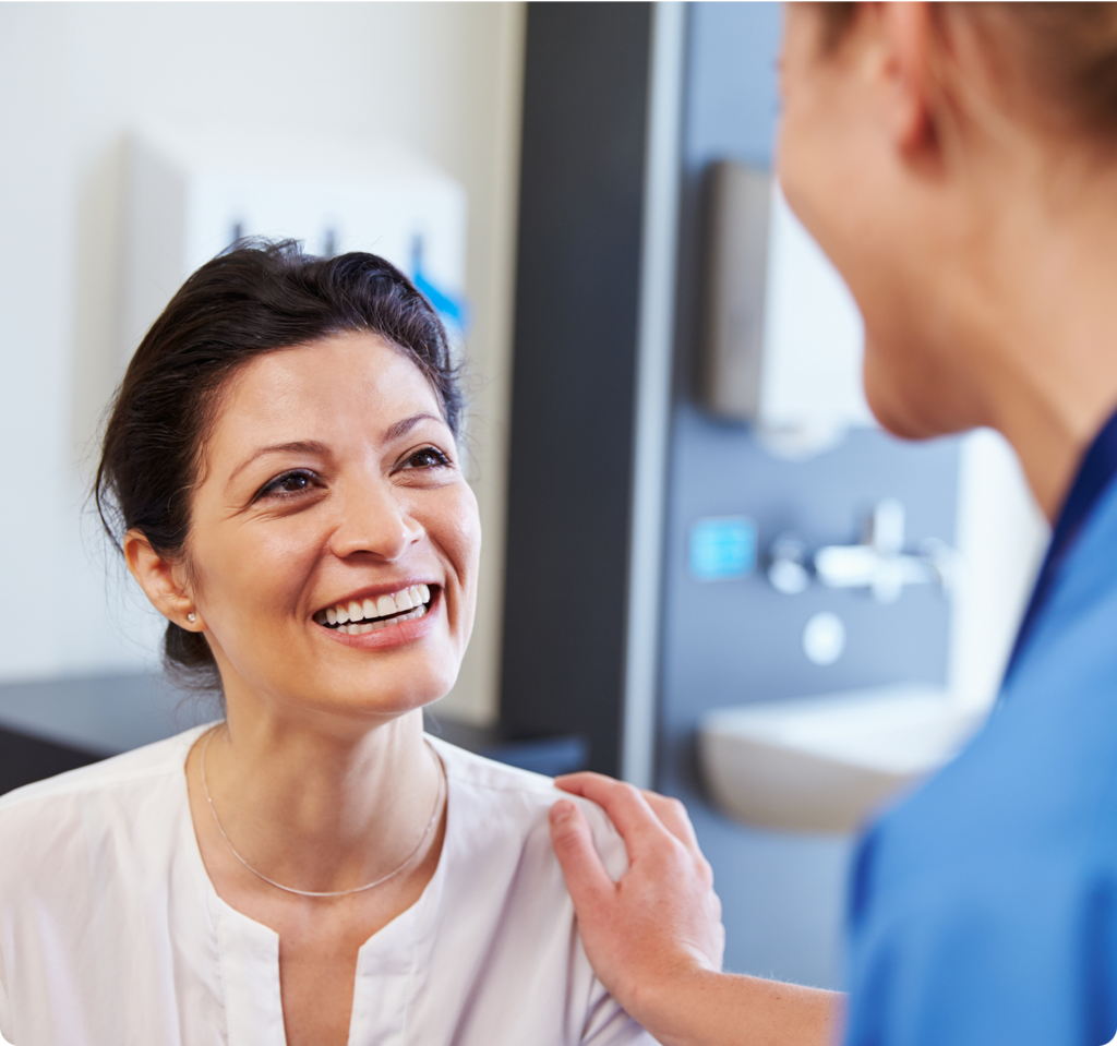 Smiling patient speaking with an oral surgeon during a dental consultation.